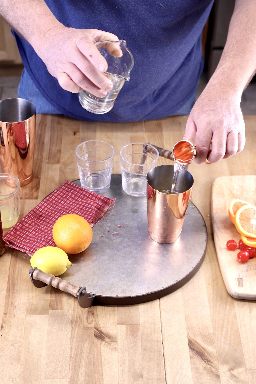 Man Pouring simple syrup into a cocktail shaker from a jigger