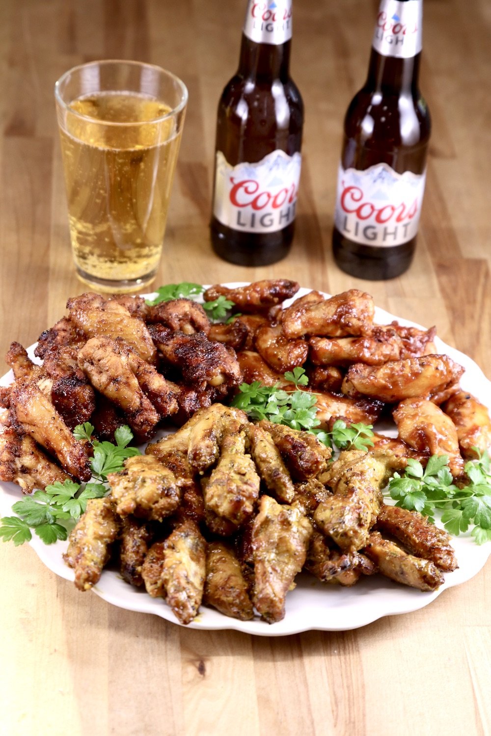 Platter of chicken wings with Coors Beer in a glass and 2 bottles