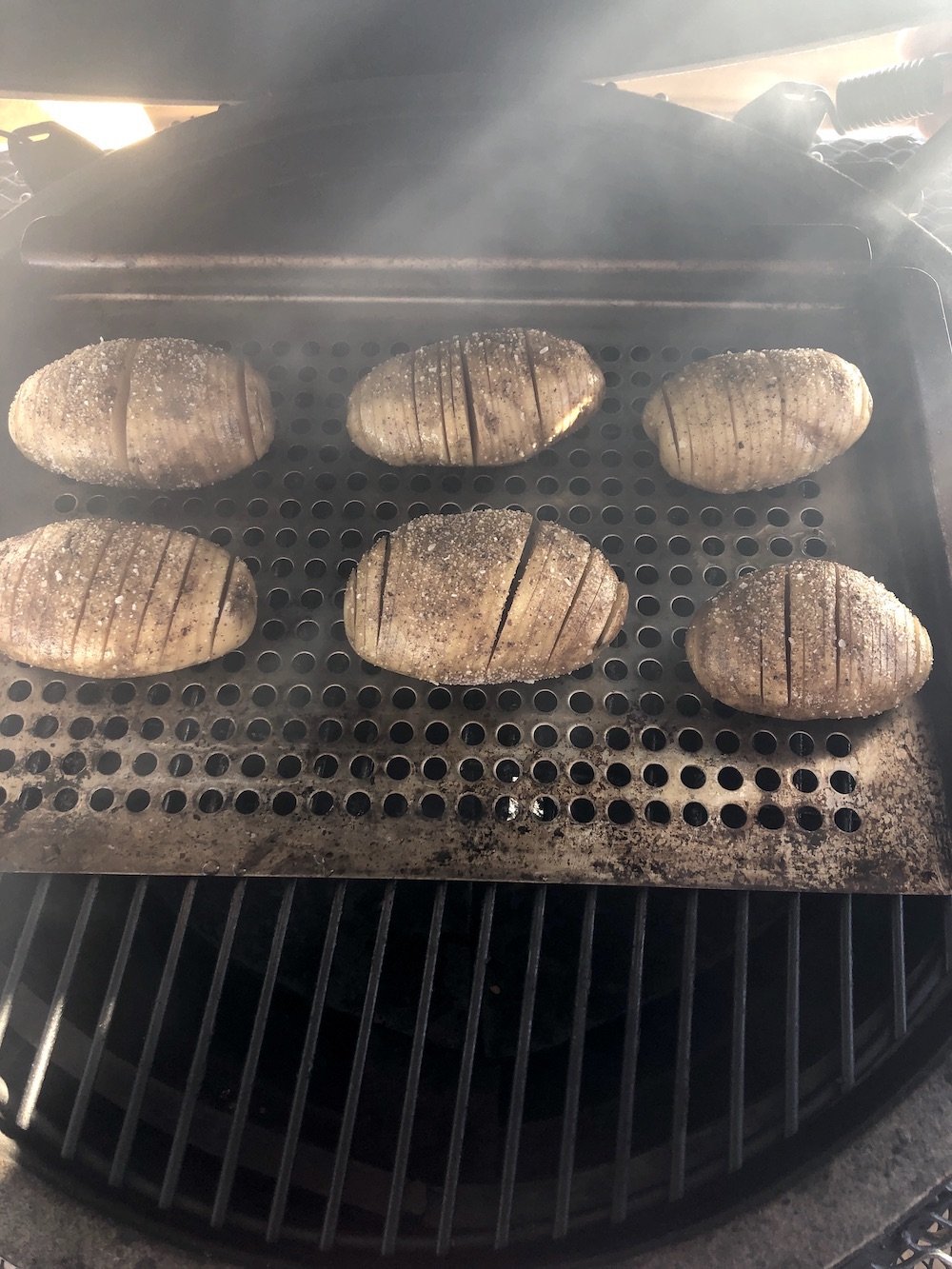 Grill with pan of fan sliced potatoes