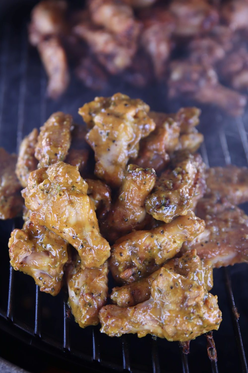 Chicken wings with mustard BBQ sauce on a grill