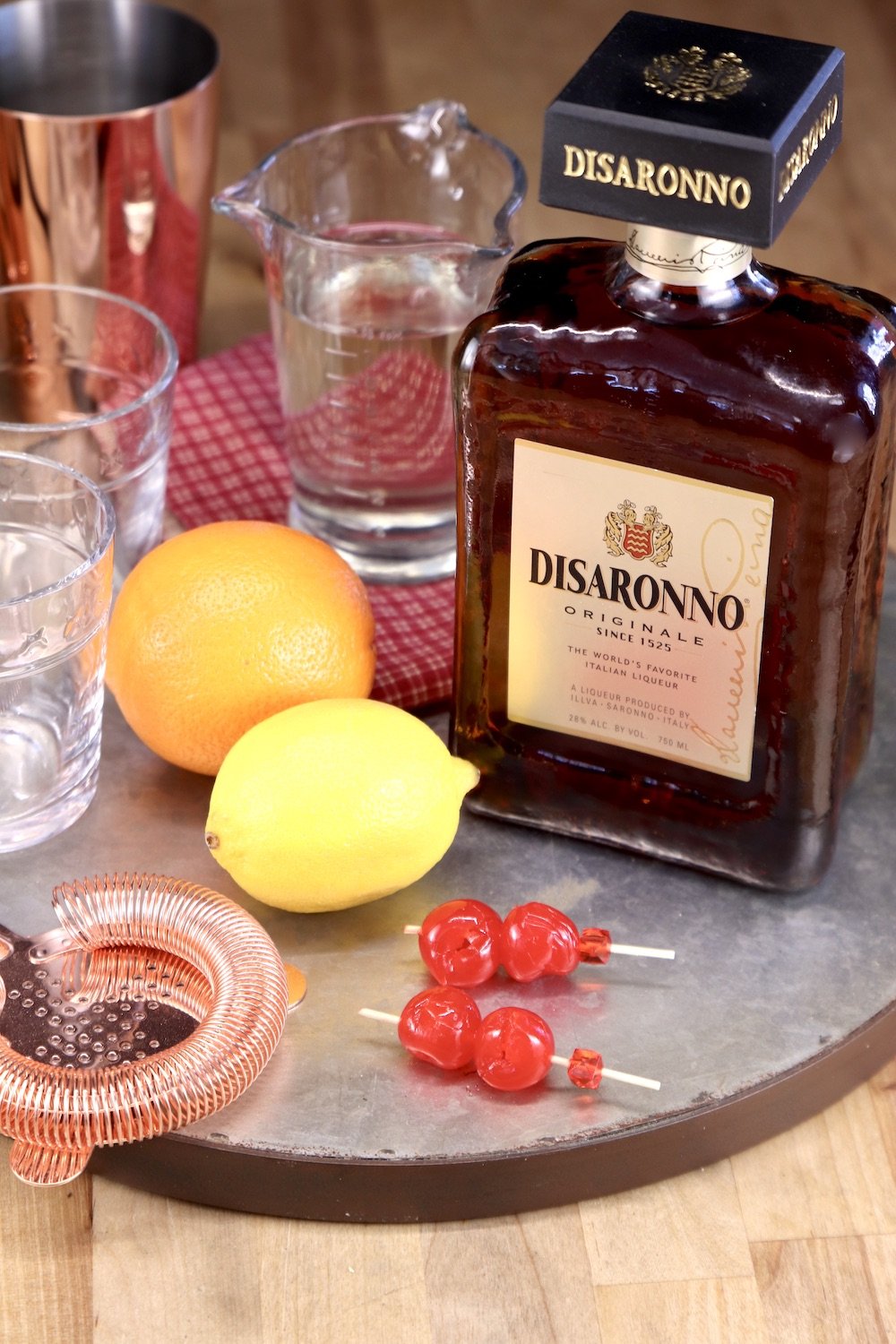 tray with Disaronno, lemon, orange, simple syrup and bar tools