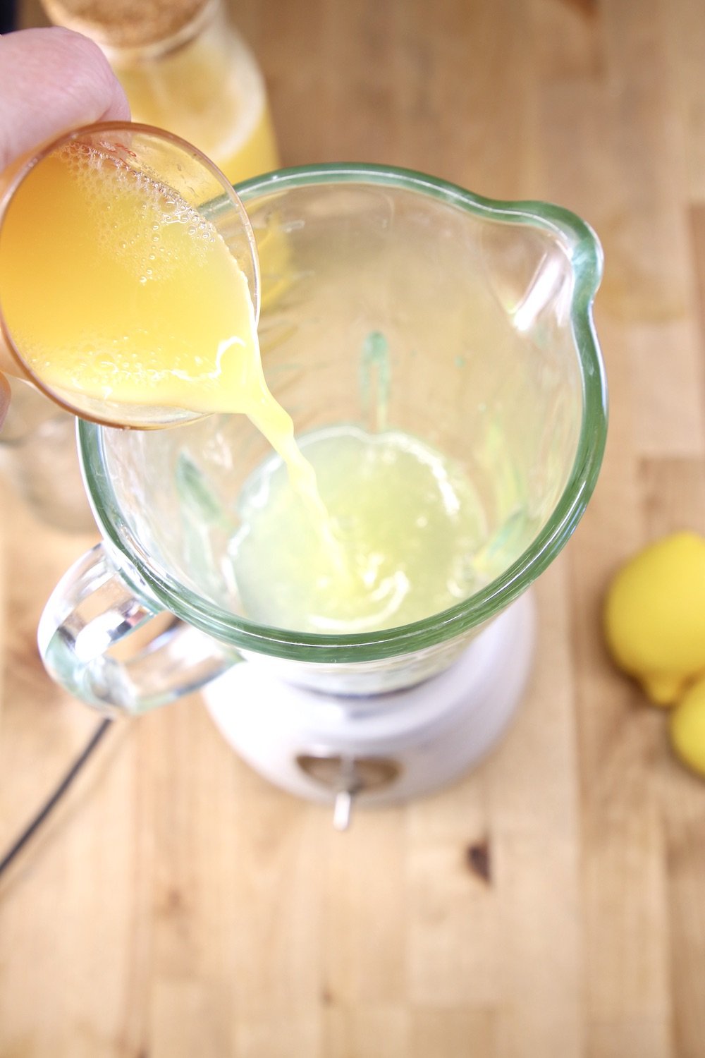 adding pineapple juice to a blender