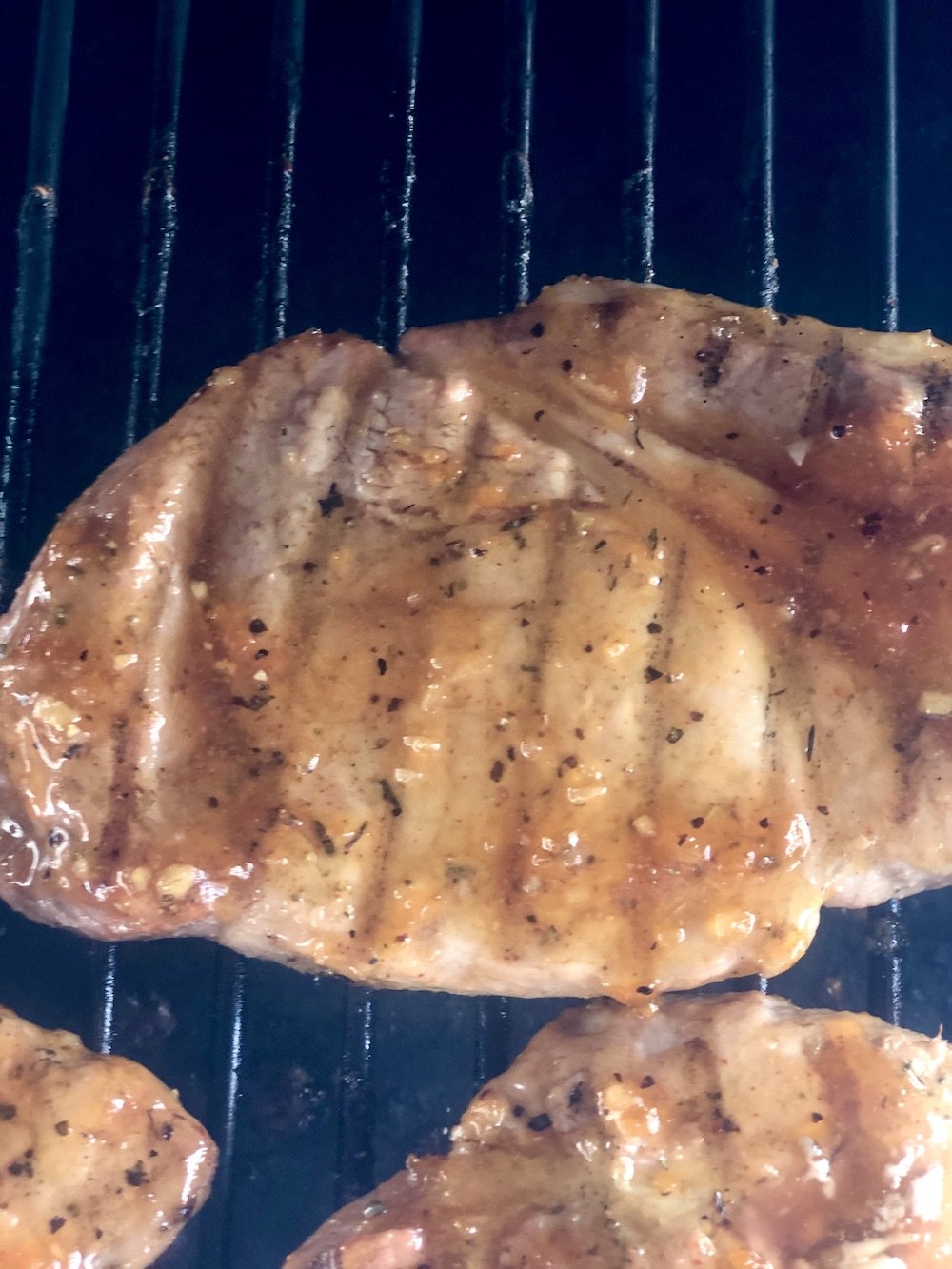 pork chops on the grill with apricot sauce