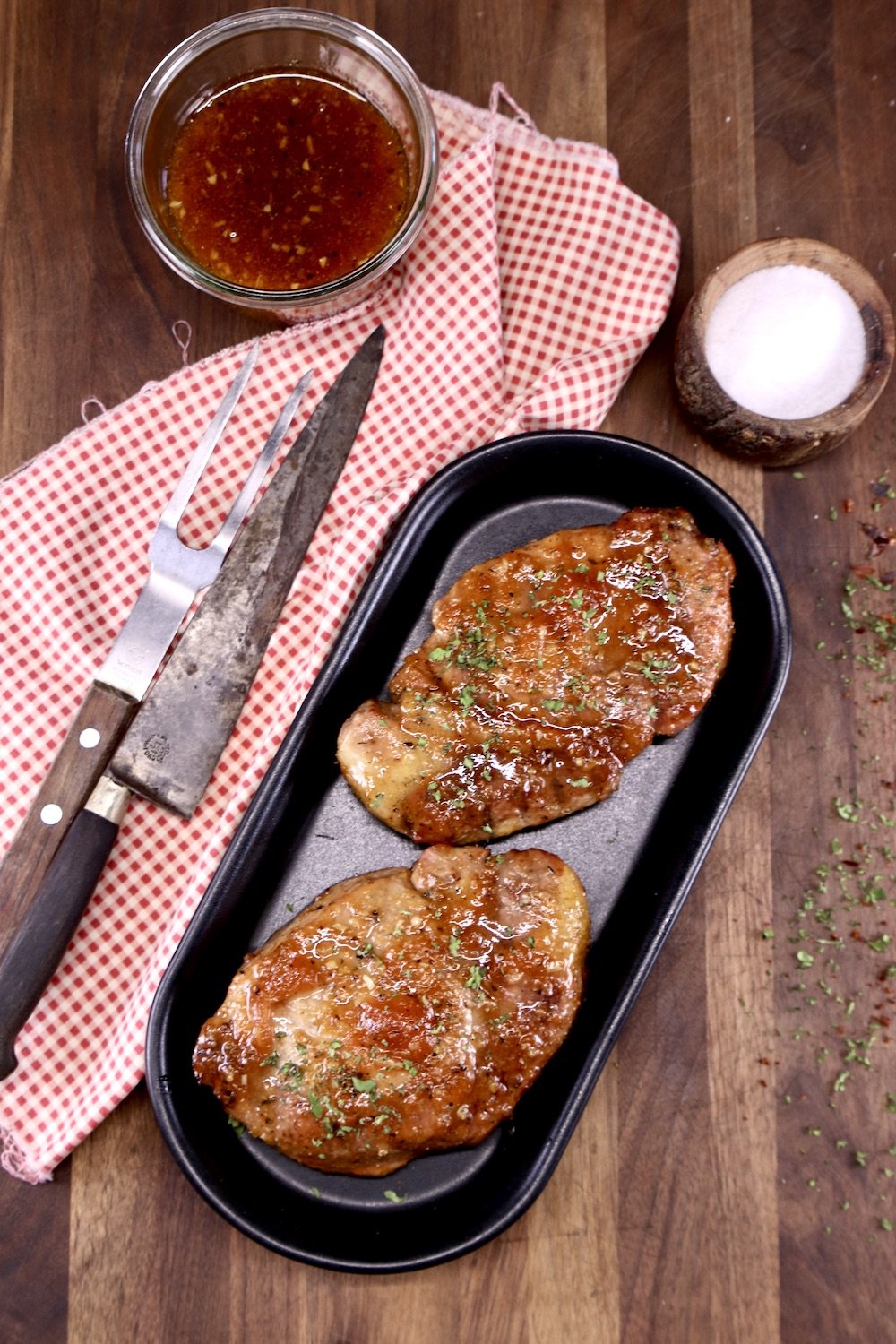 Grilled Apricot Pork Chops with sauce, knife and meat fork