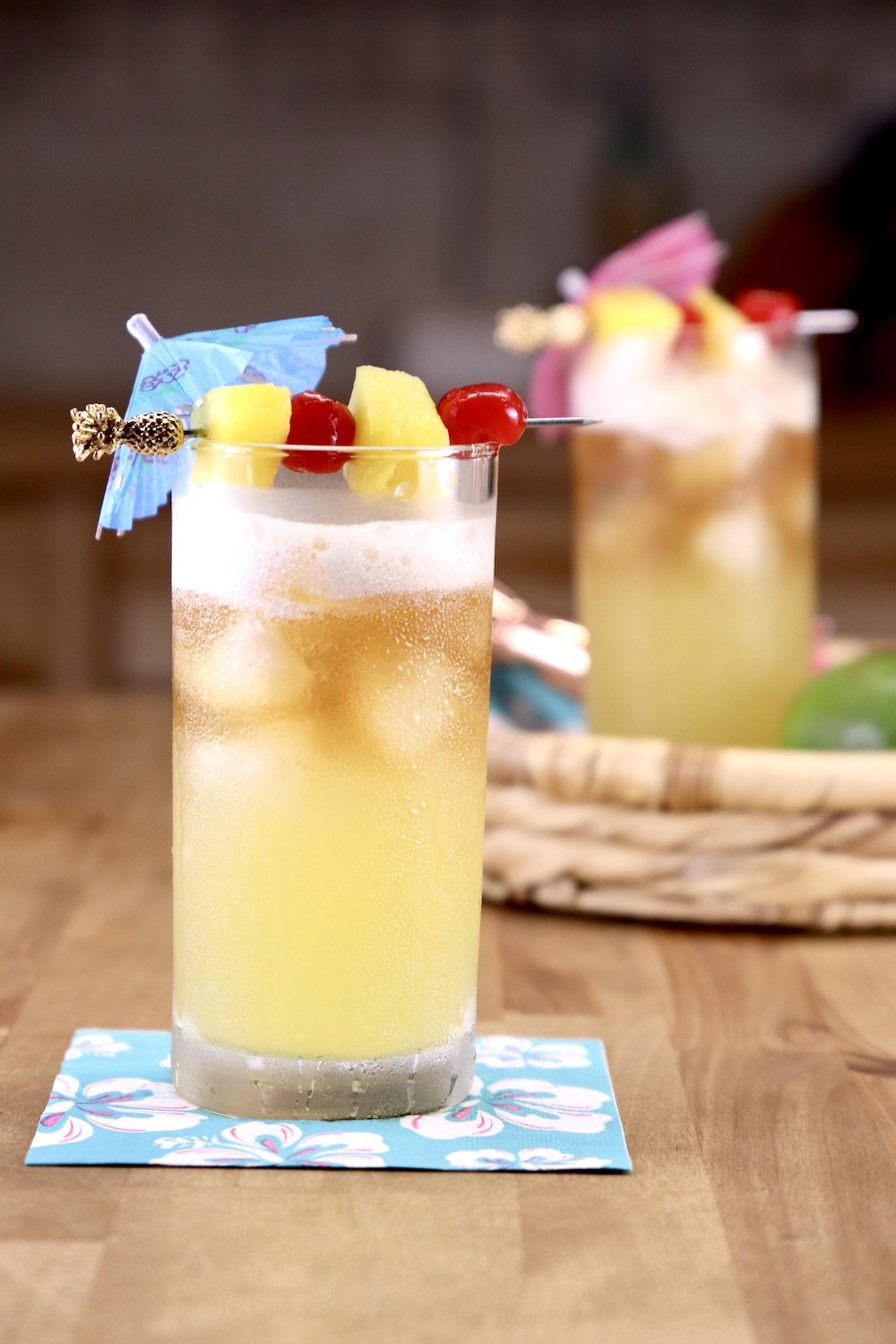 Mai Tai Cocktails with drink umbrellas, cherries and pineapple garnish