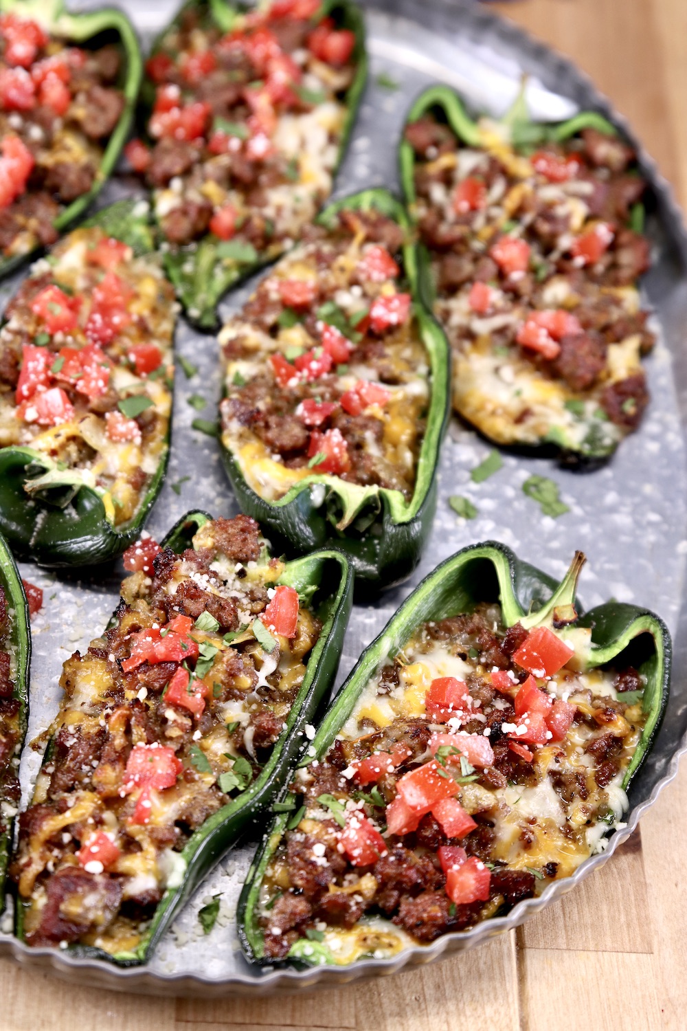 Poblano peppers stuffed with sausage and cheese topped with tomatoes