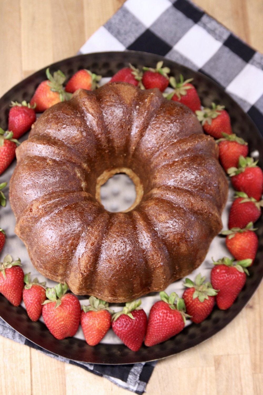 Amaretto Pound Cake - Bundt cake on a tray with fresh strawberries