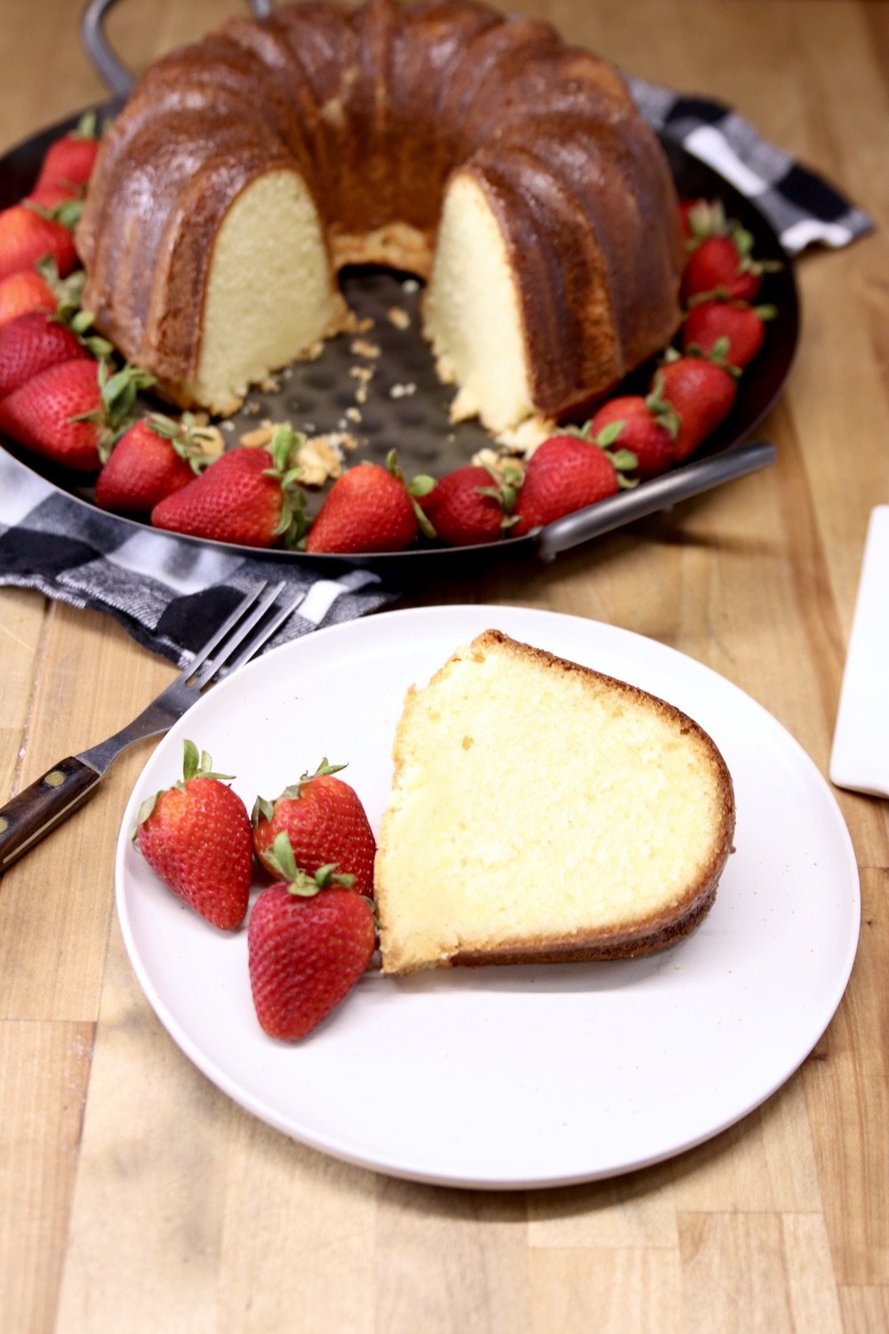 slice of pound cake with fresh strawberries on a plate