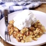 apple dump cake on a plate with a scoop of vanilla ice cream