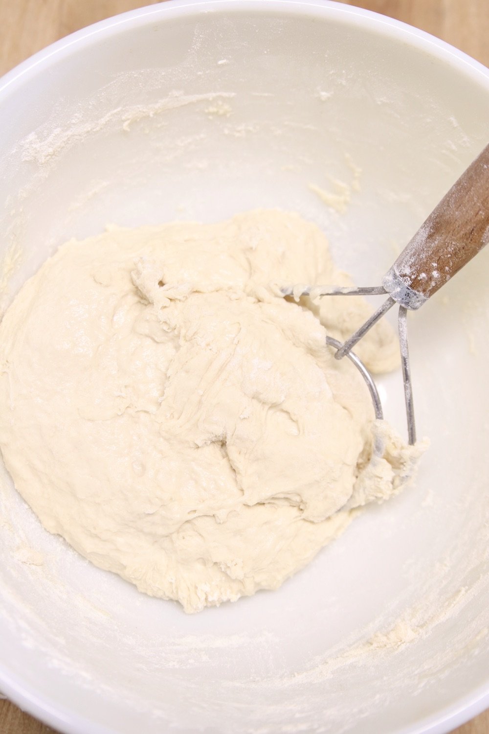 pizza dough in a bowl with dough whisk
