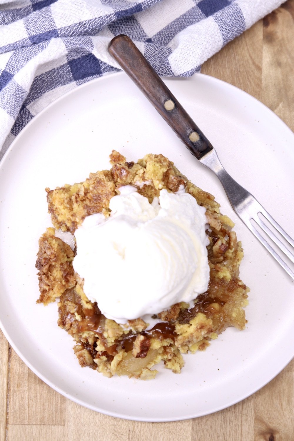 plate of apple dump cake with vanilla ice cream with a fork