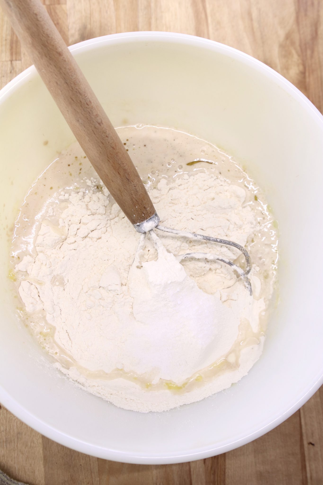 flour in a bowl with a dough whisk