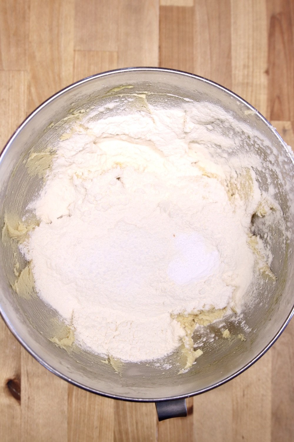 adding flour to cookie dough in a bowl