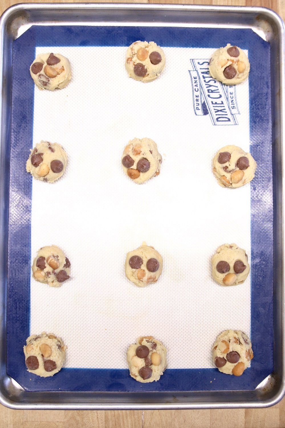 scoops of cookie dough on a lined baking sheet
