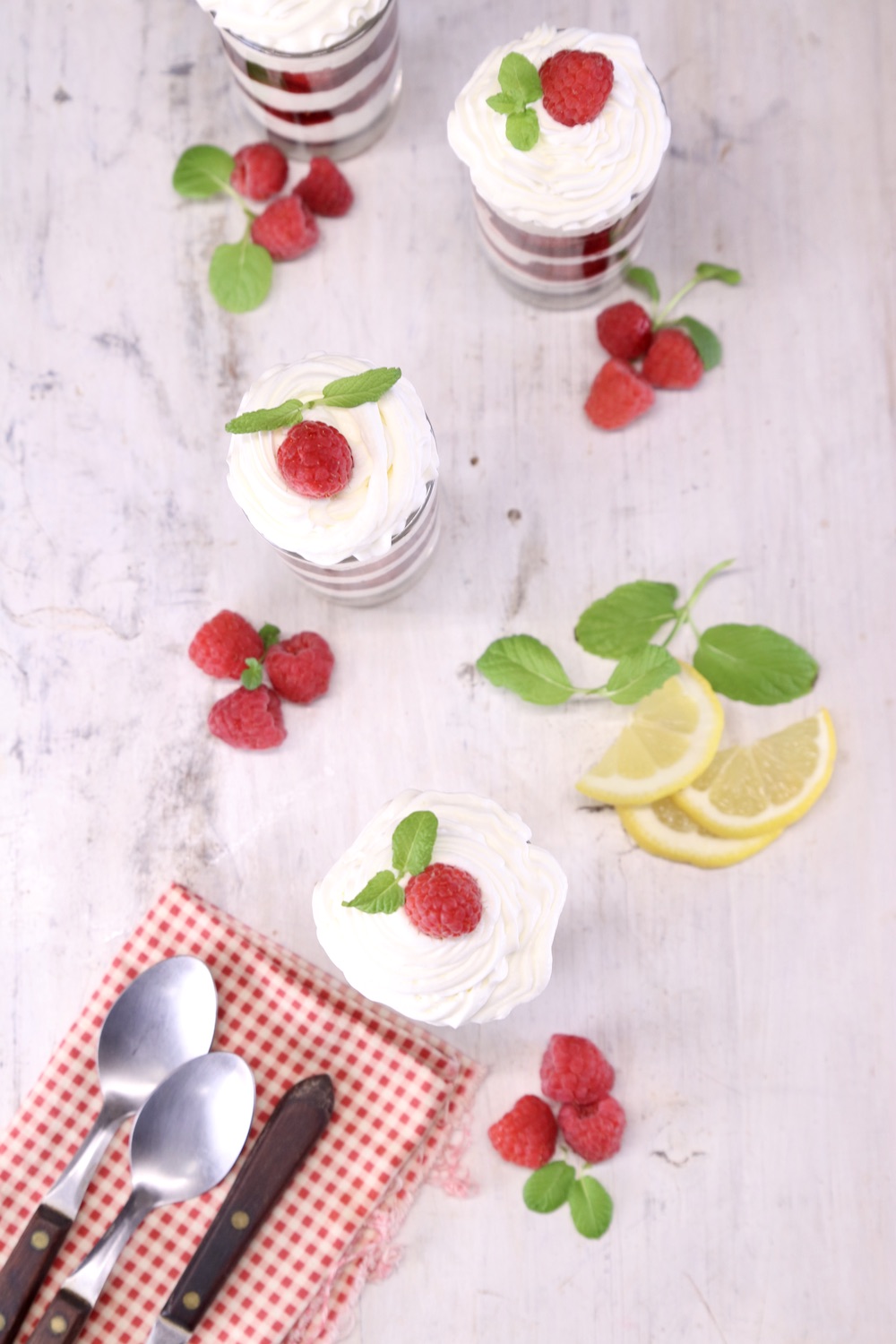 overhead of raspberry cheesecake layered dessert cups