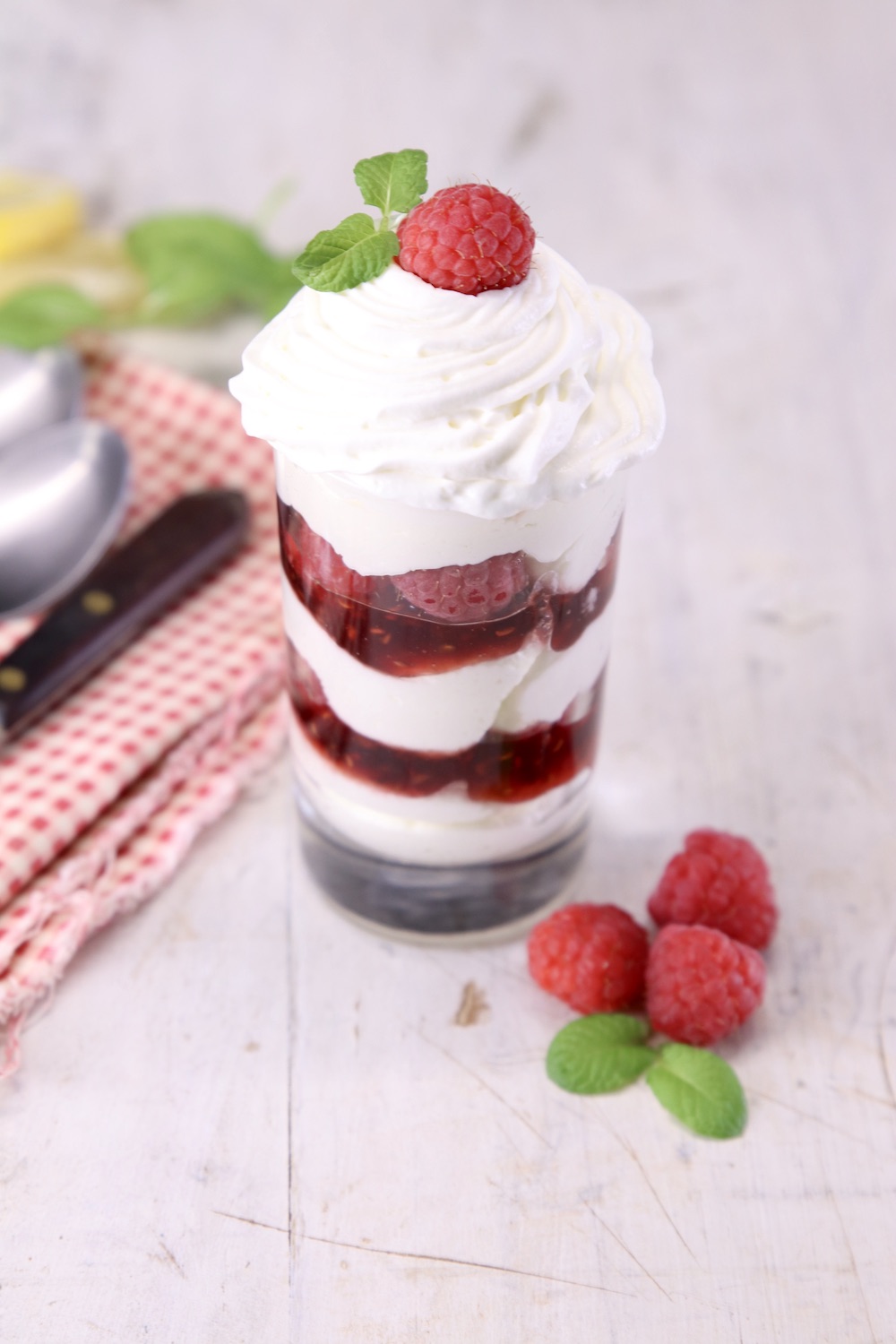 dessert glass with layered no bake raspberry cheesecake