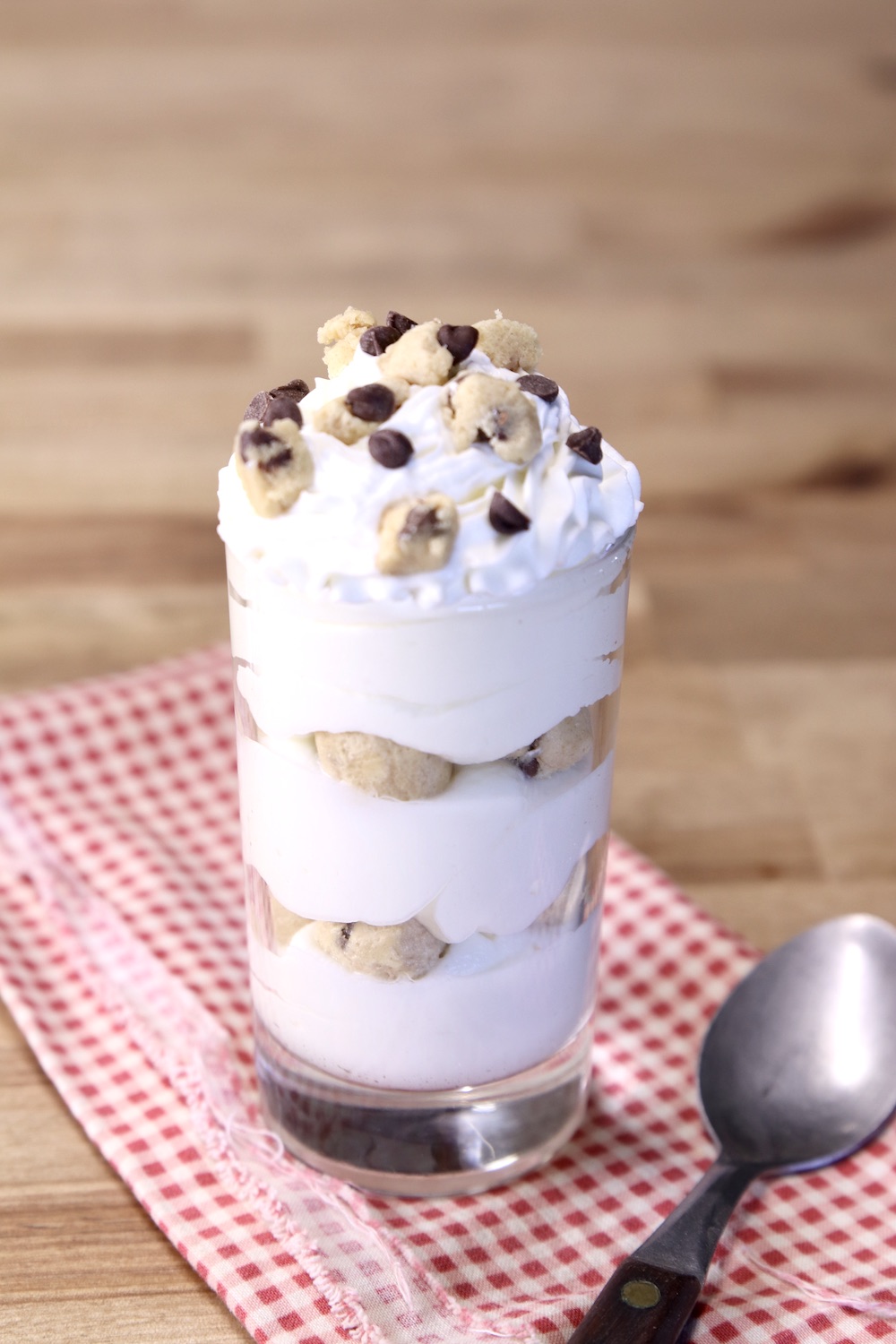 No Bake Cheesecake with cookie dough in a small glass with spoon 
