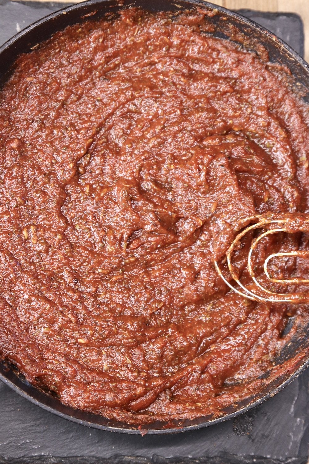 pizza sauce in a pan with a whisk