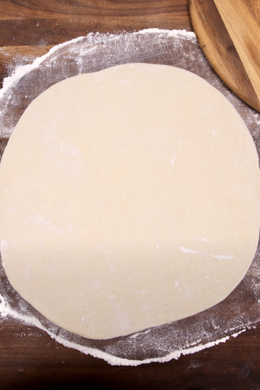 Pizza dough on a floured board - rolled into a circle