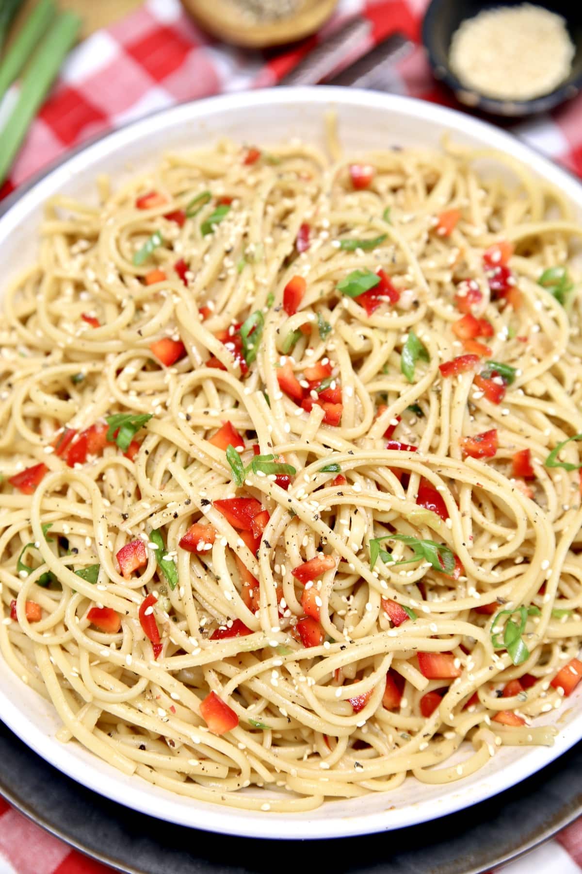 Pasta salad with red bell peppers and green onions.