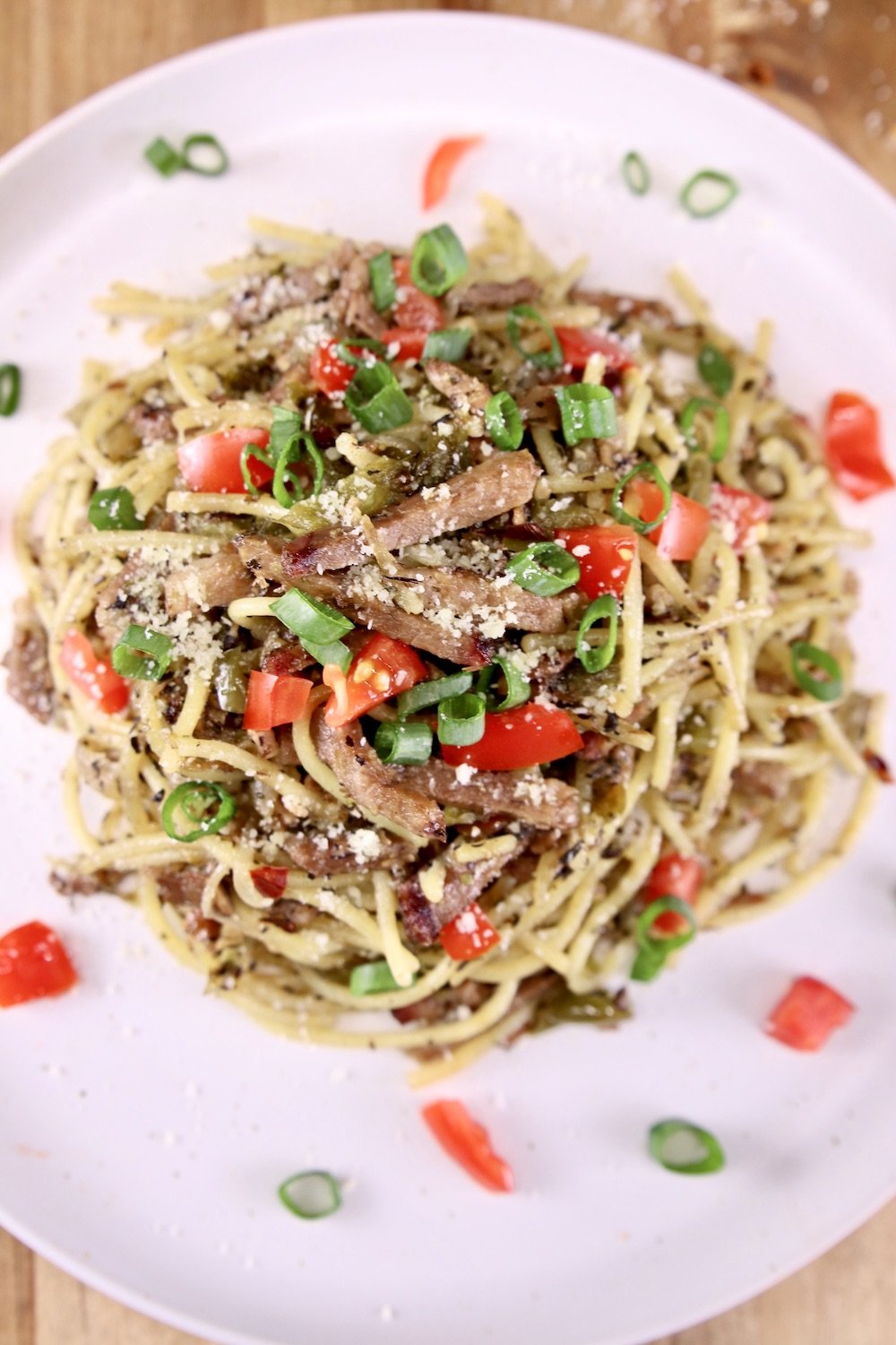 plate of brisket spaghetti with green onions and tomatoes