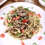 plate of brisket spaghetti with green onions and diced tomatoes