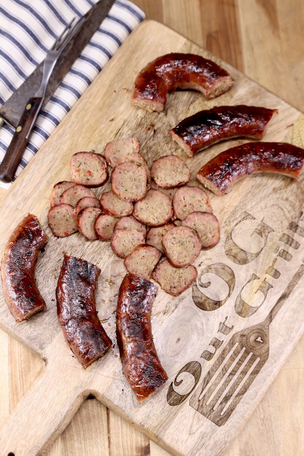 Smoked Sausage, links and slices on a cutting board with green onions