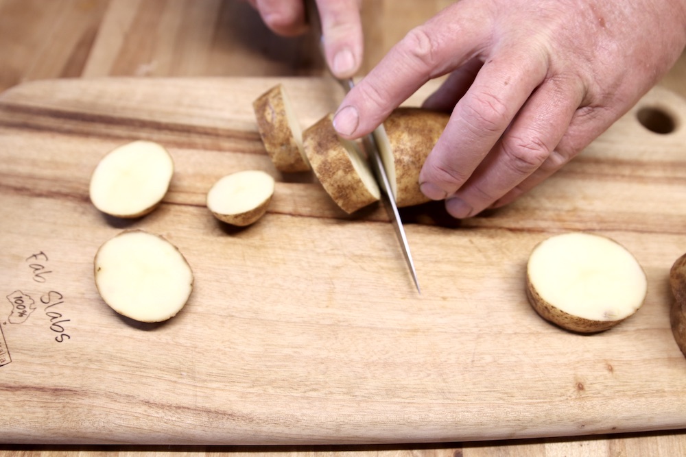 slicing potatoes on a cutting board