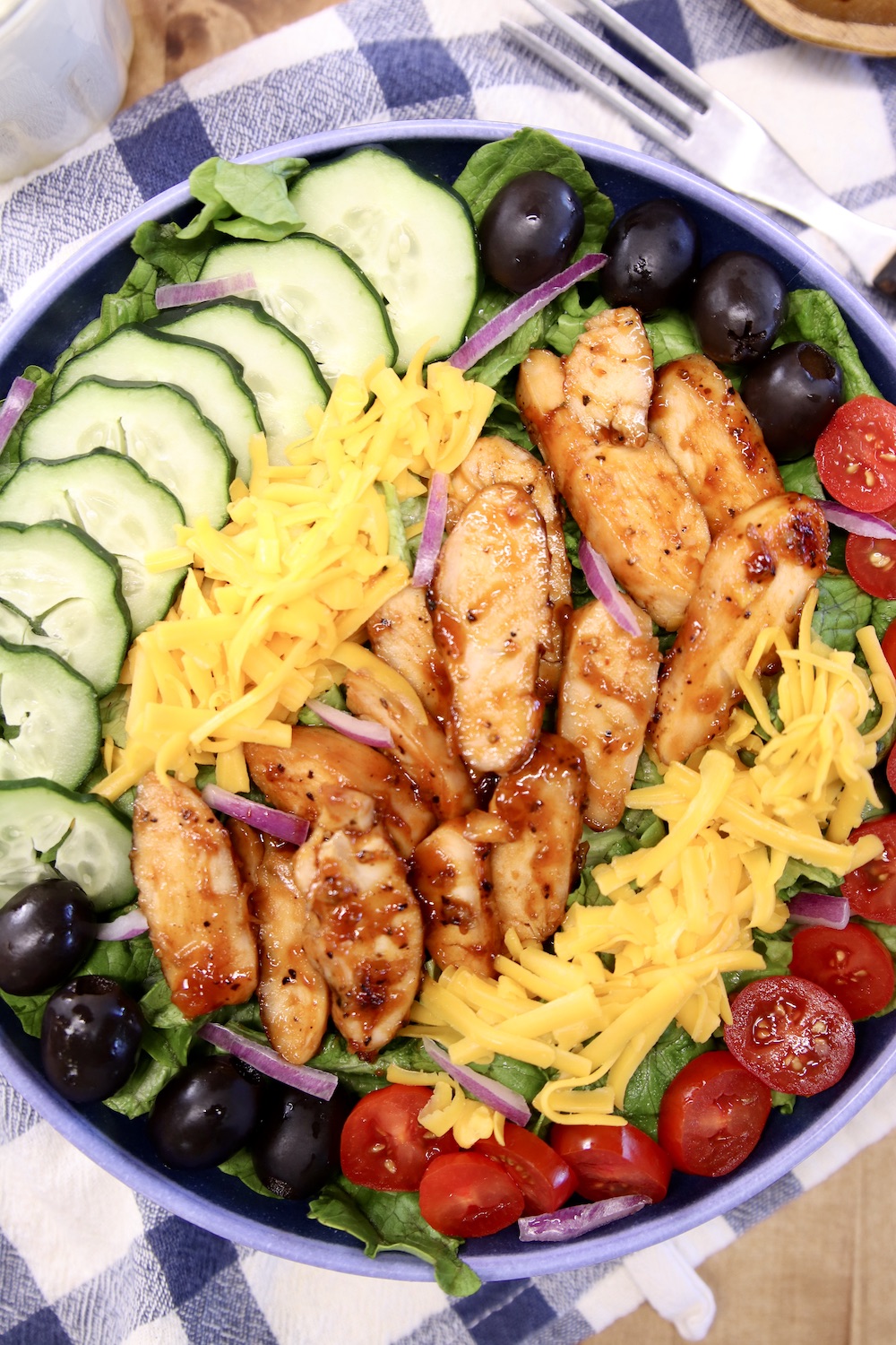 close up of chicken salad with bbq chicken, tomatoes, cheese, cucumbers, olives