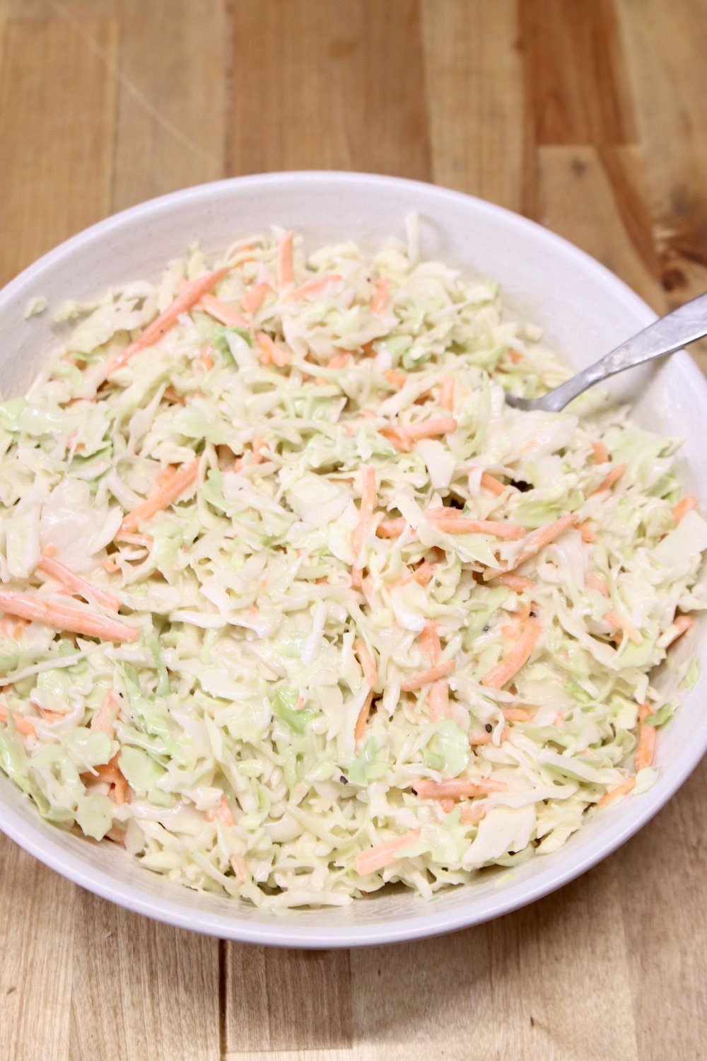 coleslaw with creamy dressing in a bowl with a spoon