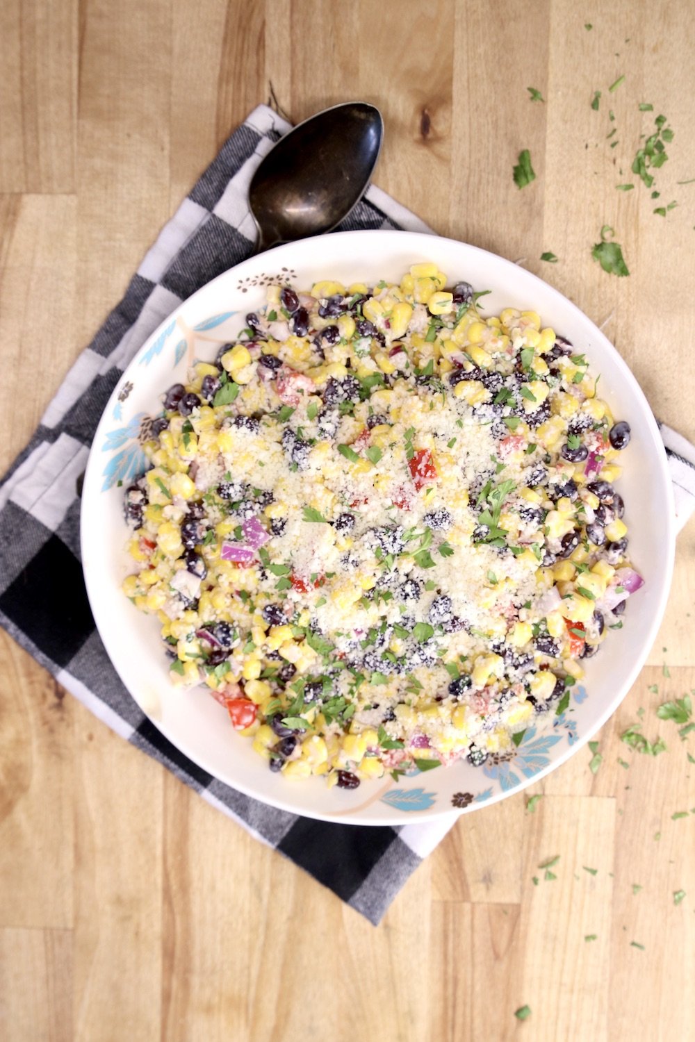 Black bean and corn salad in a bowl on a black and white check napkin