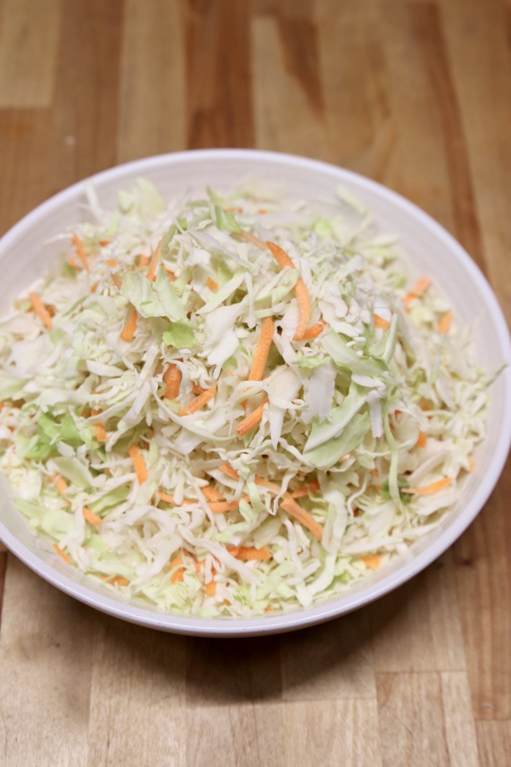 shredded cabbage and carrots in a bowl for coleslaw