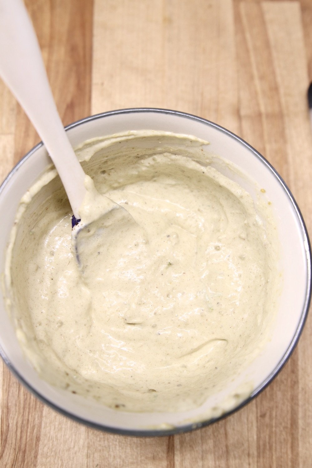 creamy green chile sauce in a bowl with a spoon