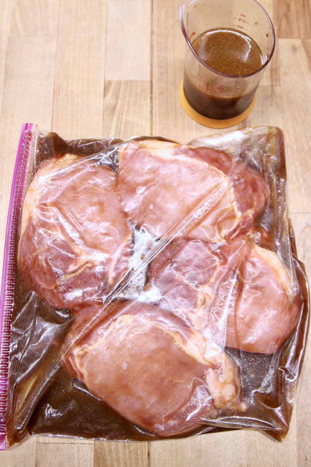4 pork chops in a ziploc bag with marinade