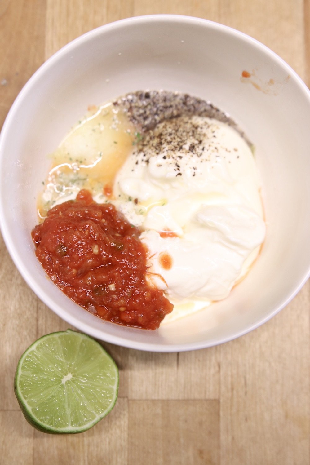salsa, lime juice, mayo, sour cream in a bowl with salt and pepper, spices
