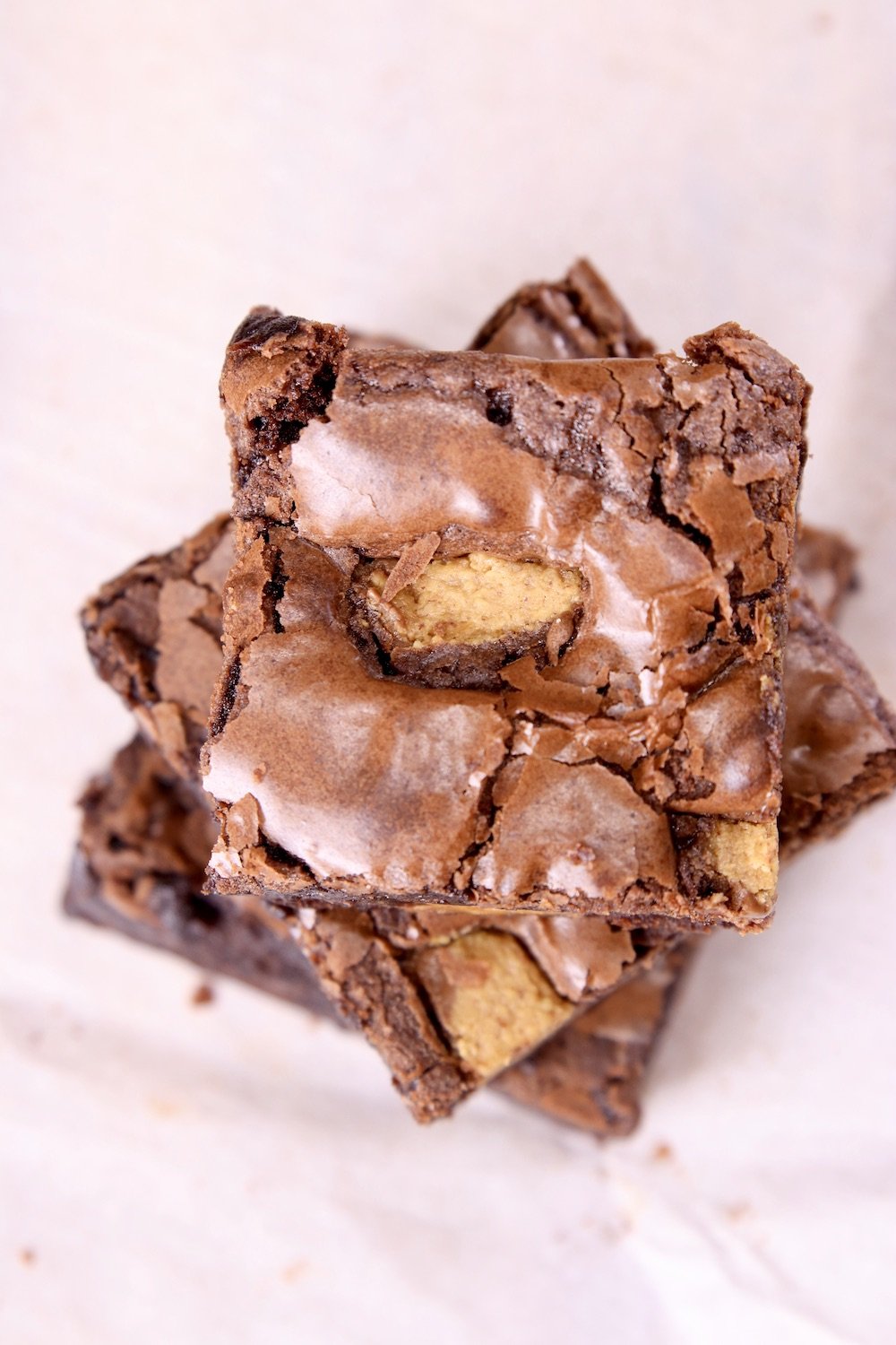 peanut butter cup brownies sliced and stacked on parchment paper