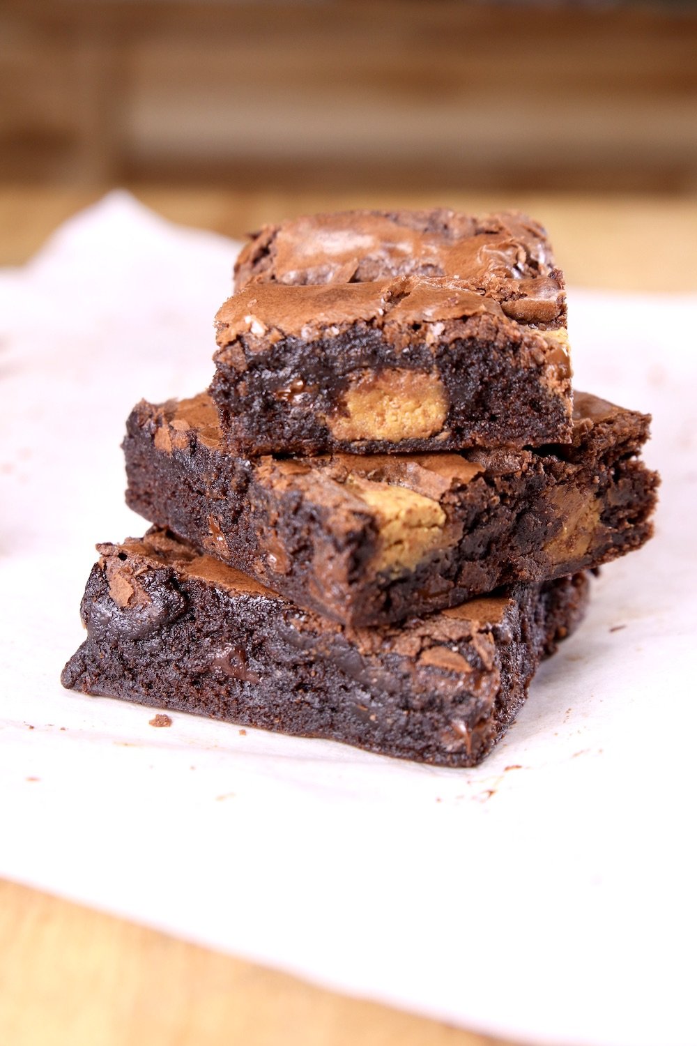 sliced peanut butter cup brownies - 3 stacked on parchment paper