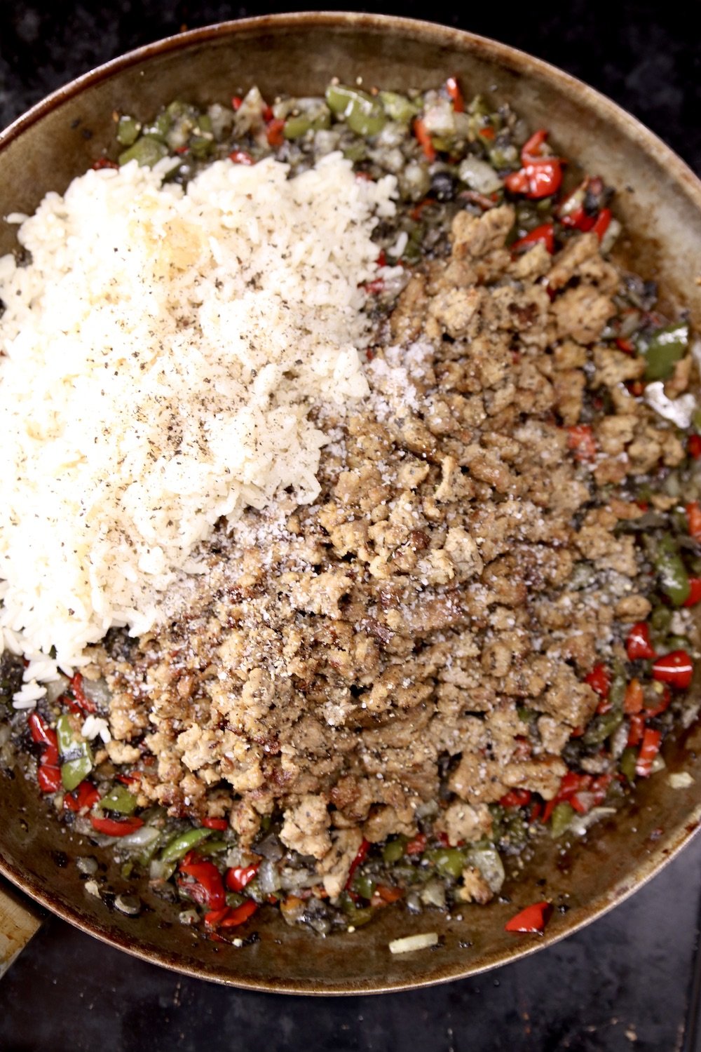 Skillet with cooked peppers, sausage and white rice