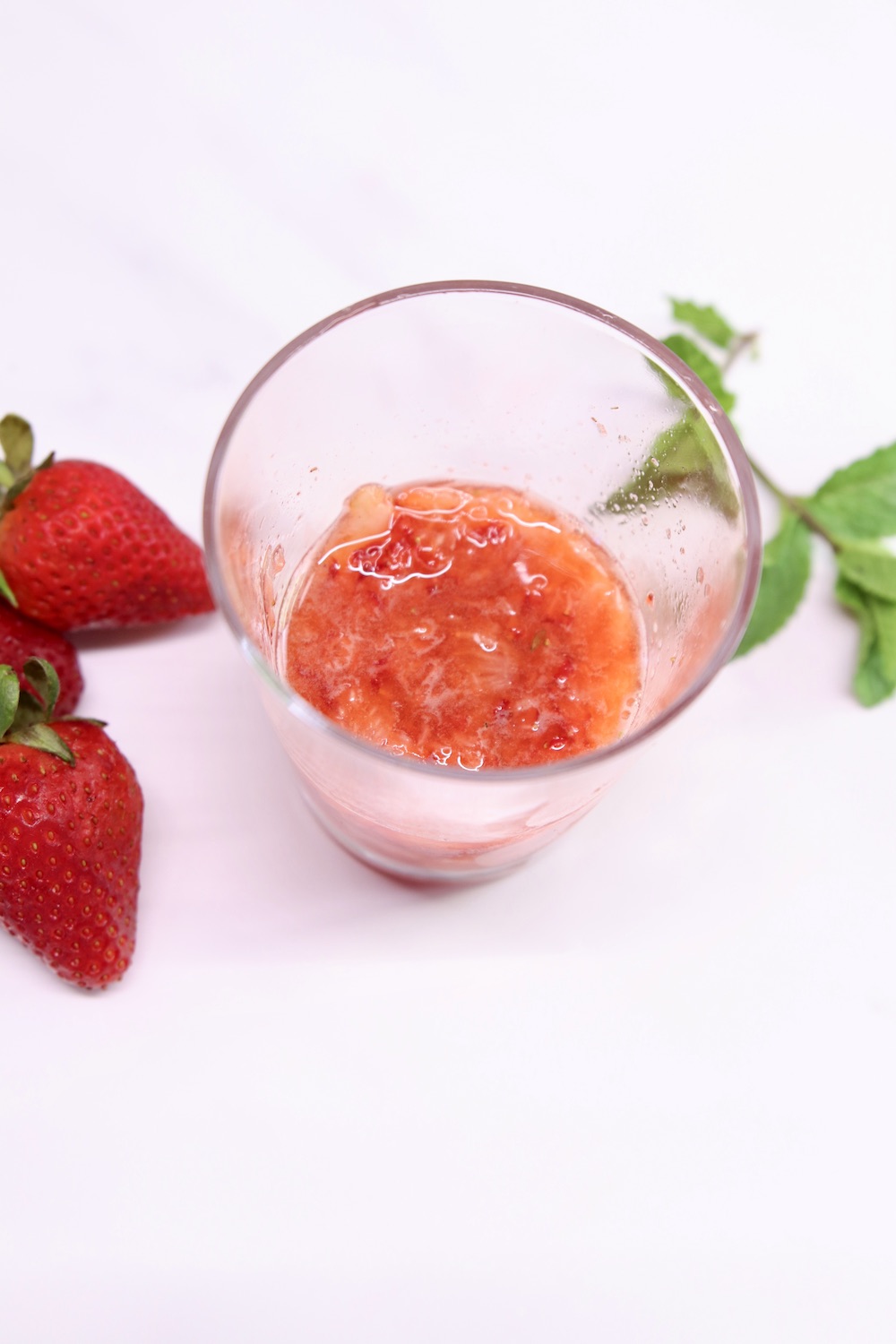 muddled strawberries in a glass