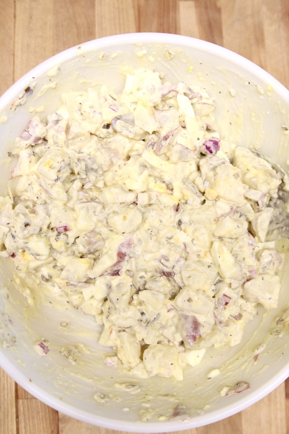 creamy potato salad with red onion in a bowl