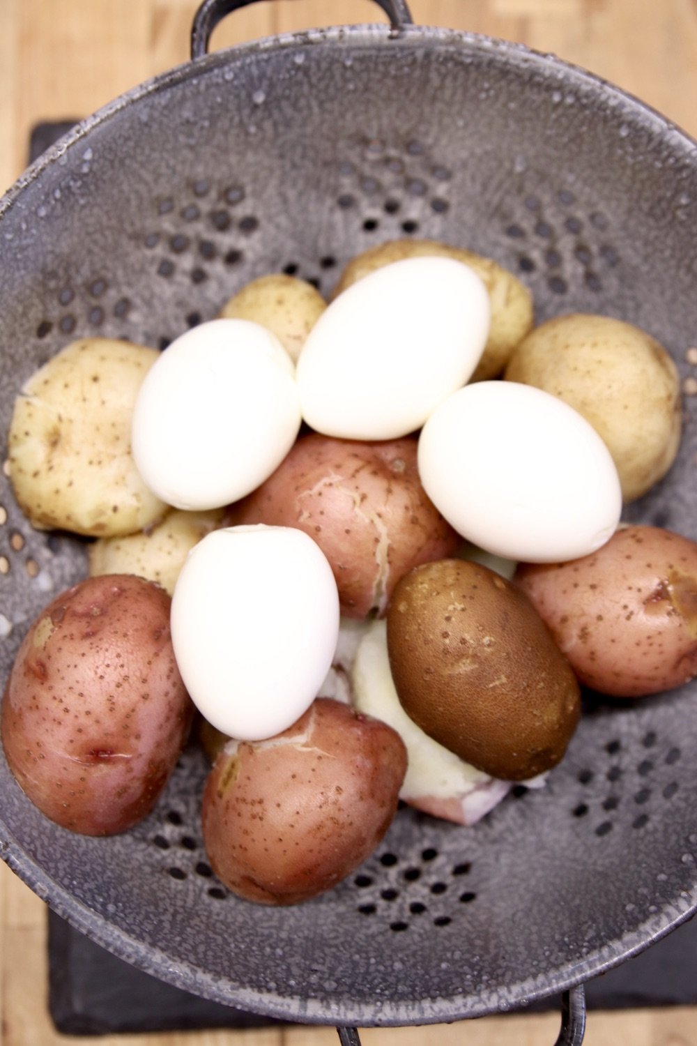 colander with boiled potatoes and hard boiled eggs