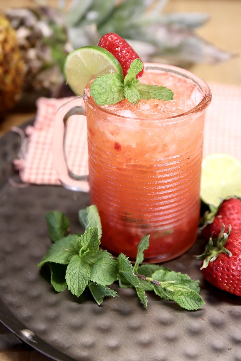 strawberry pineapple mojito with lime, strawberry and mint garnish