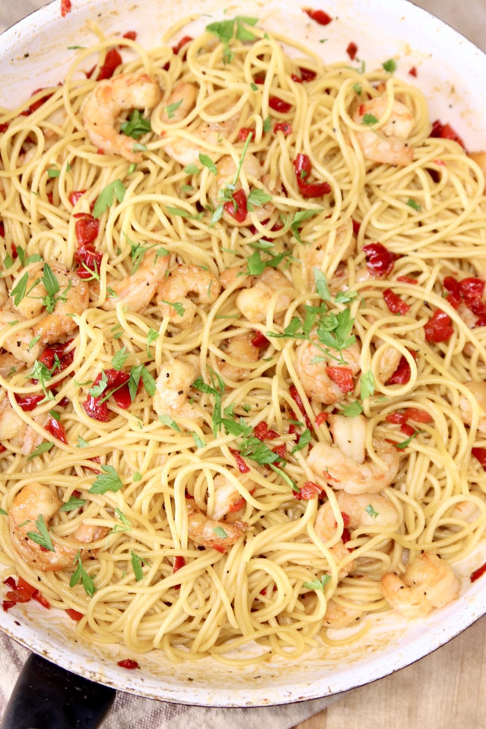 closeup of skillet of shrimp spaghetti with red peppers