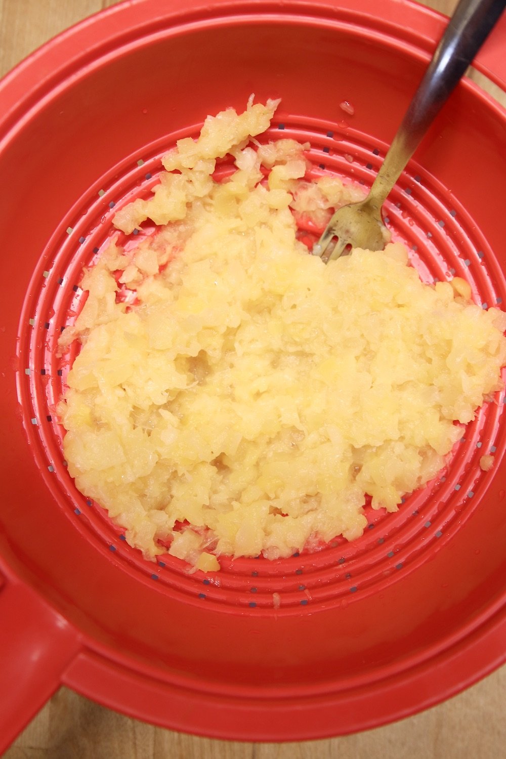 crushed pineapple drained in a red colander