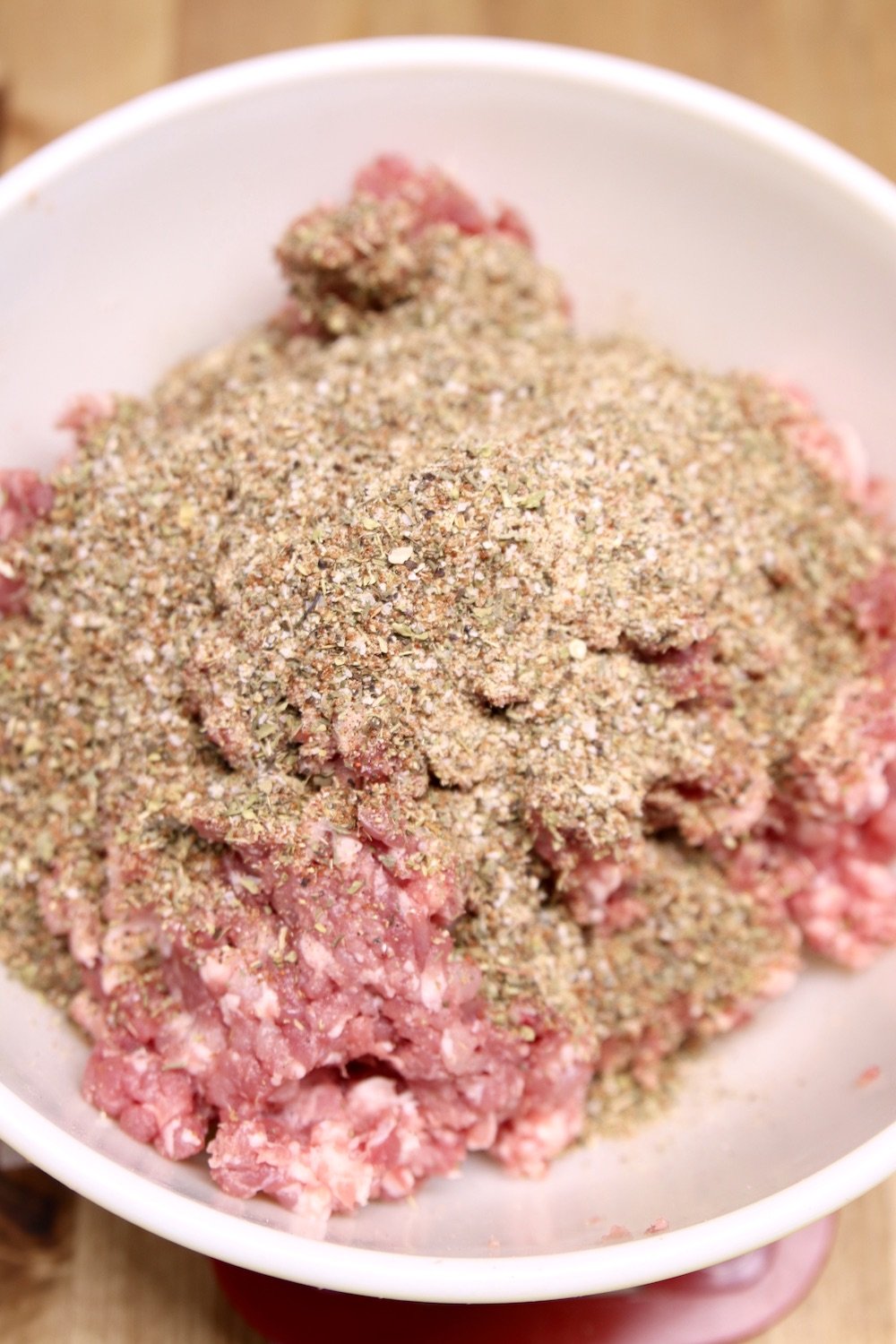 ground pork and Italian sausage spices in a bowl