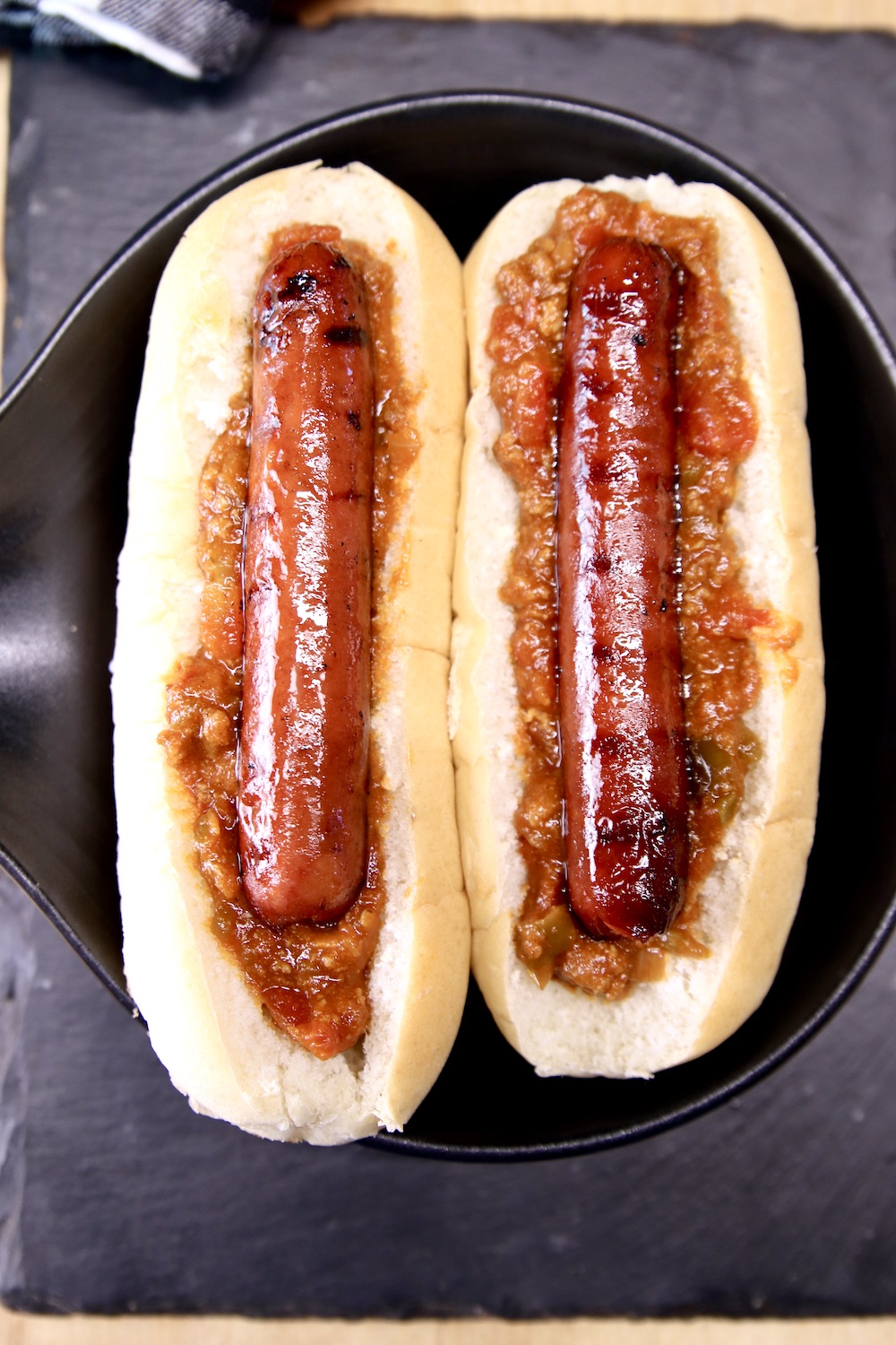 2 hoagie buns with chili and hot dogs