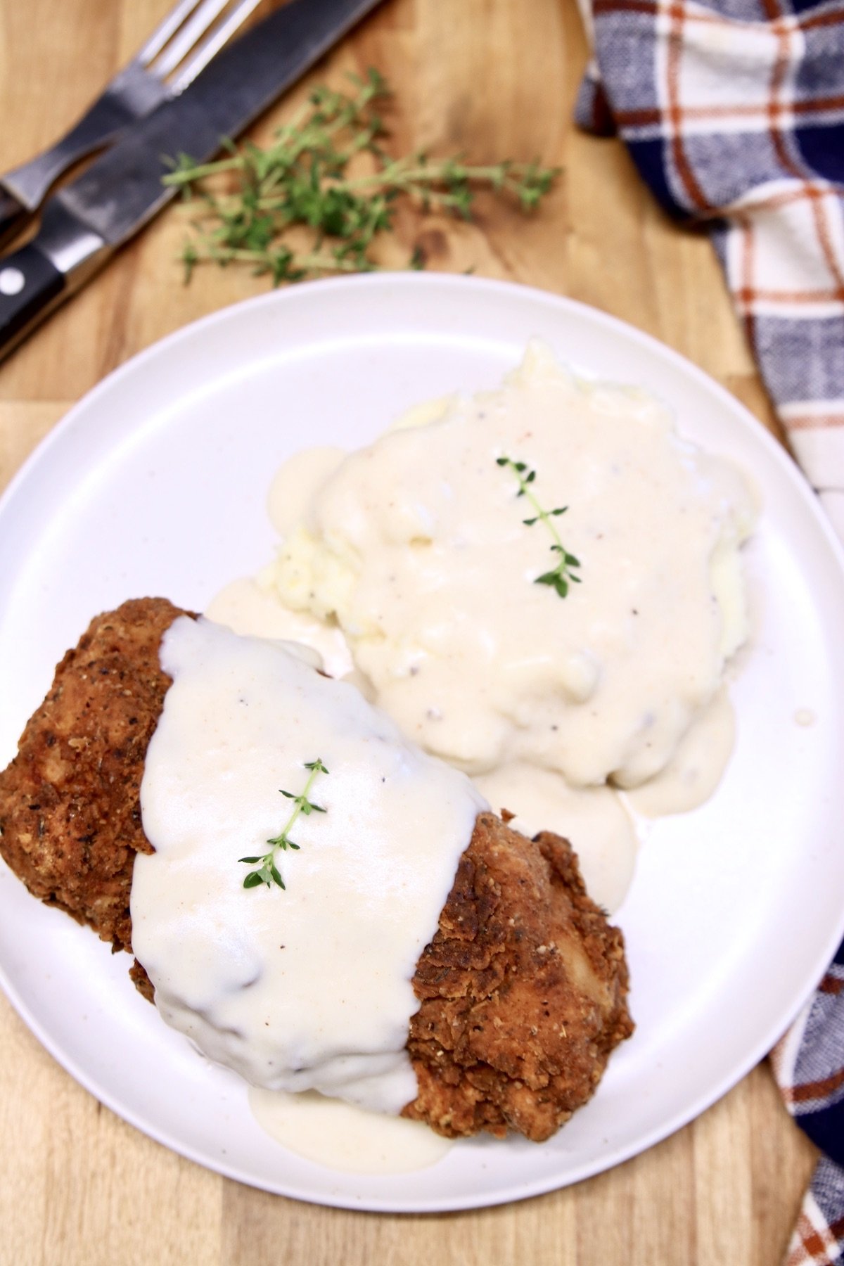 deep fried pork chop with gravy and mashed potatoes
