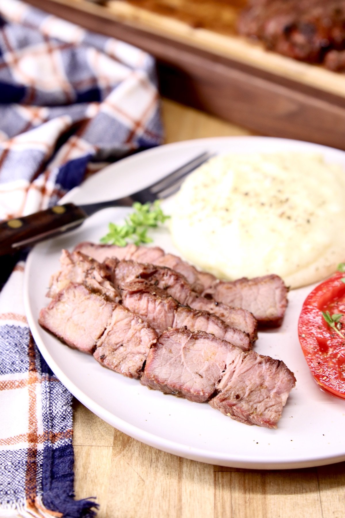 Grilled roast beef slices on a plate with mashed potatoes