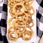 platter of onion rings on a black and white check napkin