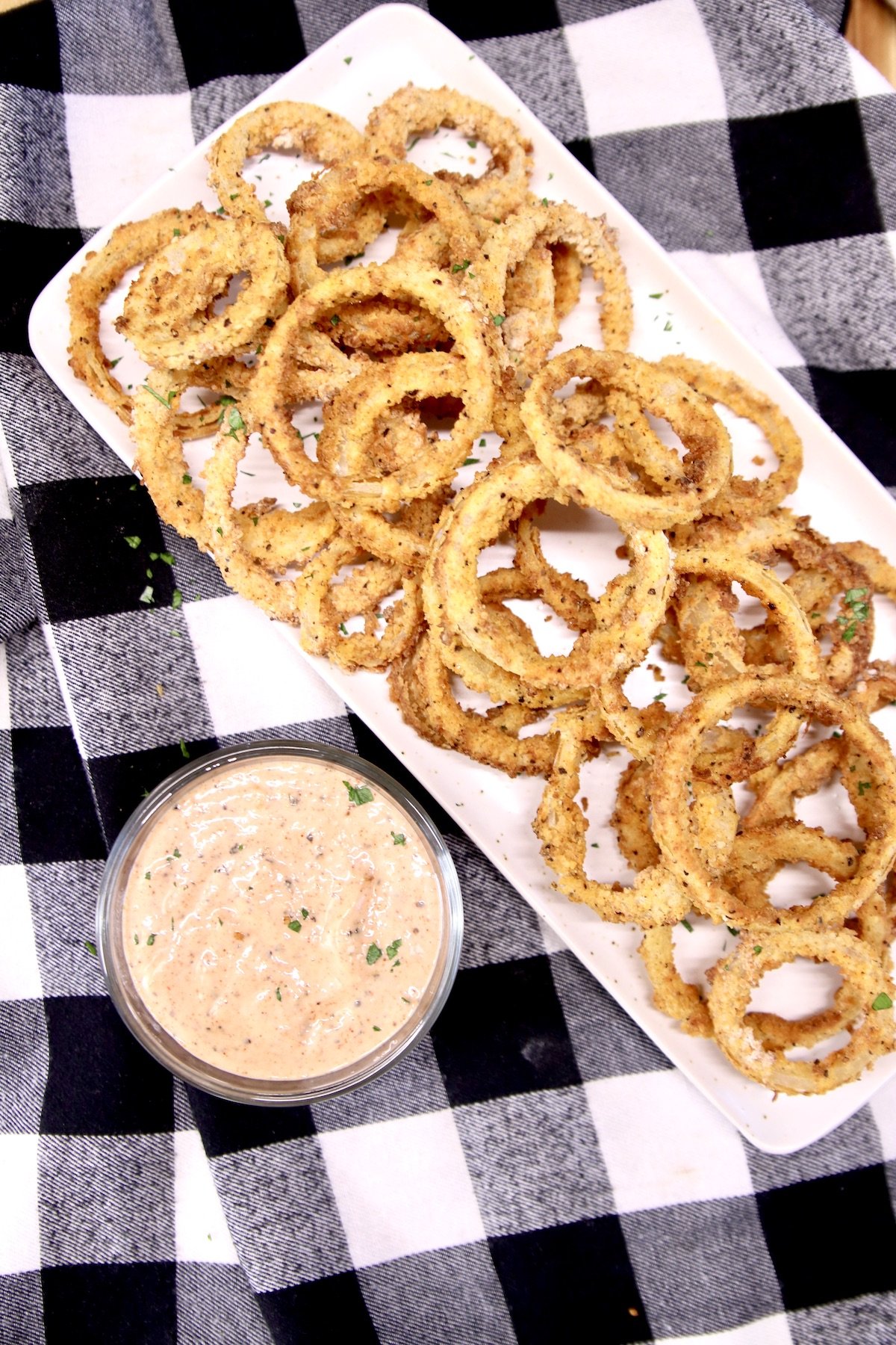 onion rings on a platter with dipping sauce